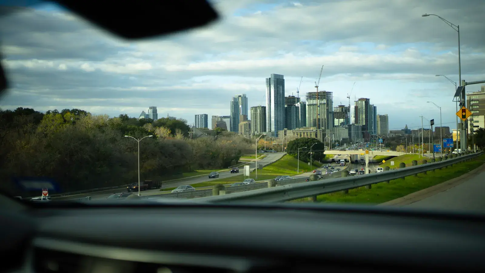 Dynamic view of Austin skyline from a car, capturing skyscrapers and urban life.