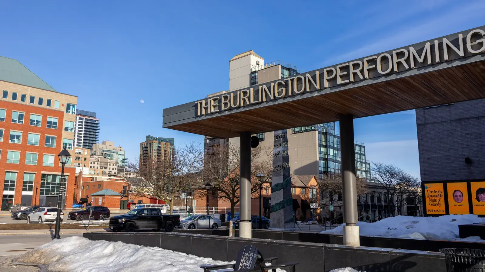 The Burlington Performing Arts Center with its distinctive cantilevered roof sign, surrounded by urban buildings and snow on
